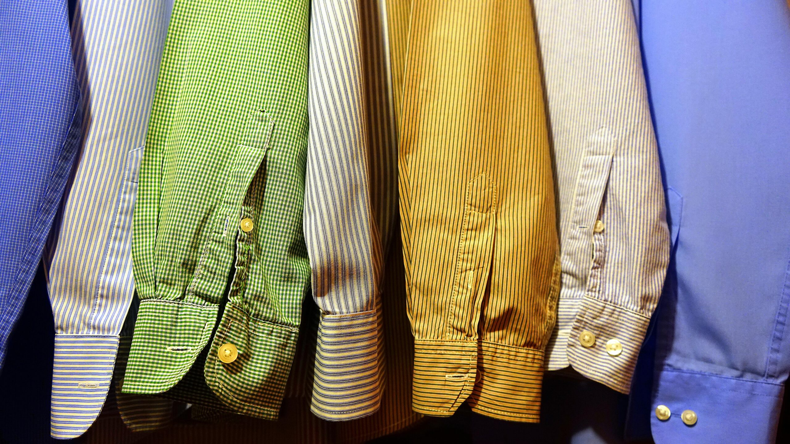 A row of vibrant, striped shirts hanging neatly, showcasing fashion variety.